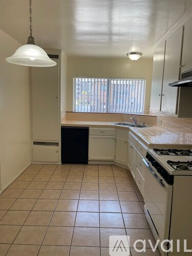 A kitchen with white cabinets and a black dishwasher.
