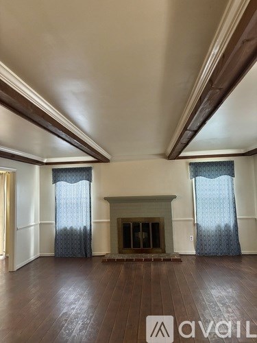 A living room with a fireplace and wood flooring.