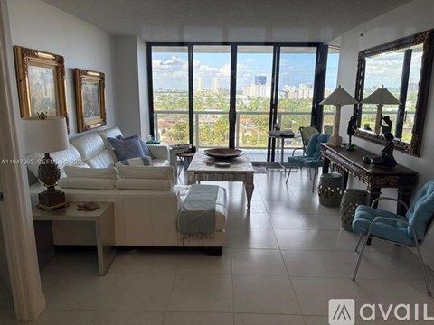 A living room with white furniture and a view of the city.