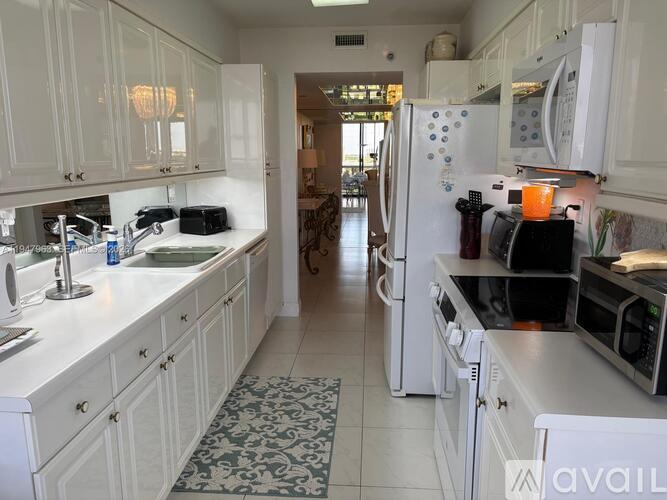 A kitchen with white cabinets and appliances.