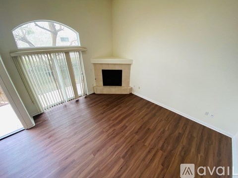 A room with a fireplace and wooden flooring.
