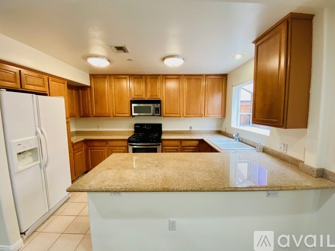 A kitchen with wooden cabinets and a granite countertop.