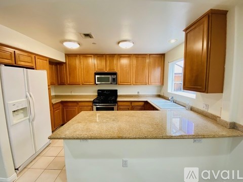 A kitchen with wooden cabinets and a granite countertop.