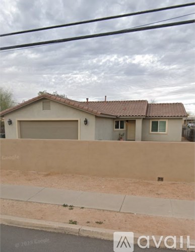 A house with a beige wall and a brown roof is shown.