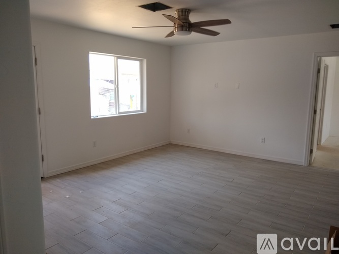 A room with a ceiling fan and a window.