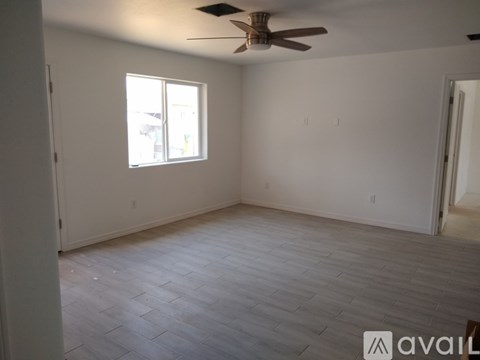 A room with a ceiling fan and a window.
