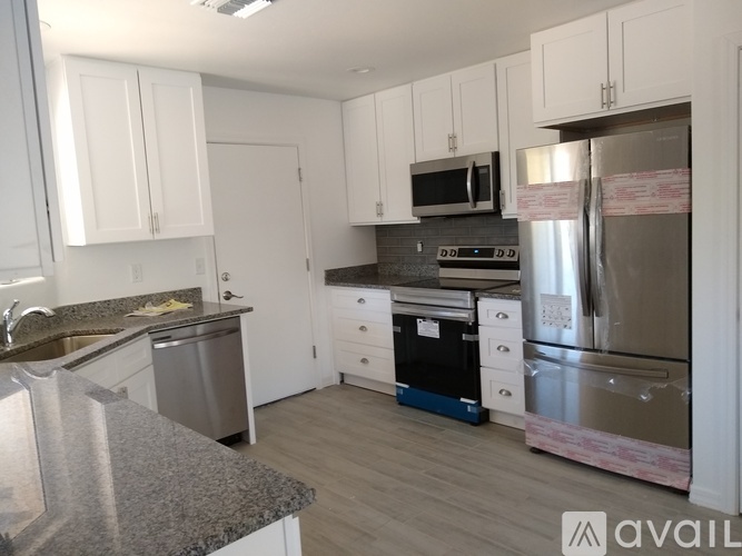 A kitchen with white cabinets and a granite countertop.