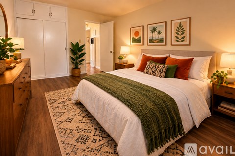 A bedroom with a large bed and a green throw blanket.