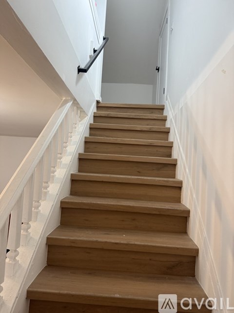 A wooden staircase with white balusters.