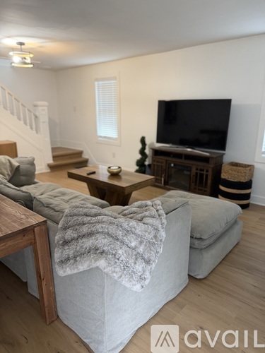A living room with a grey couch and a television.