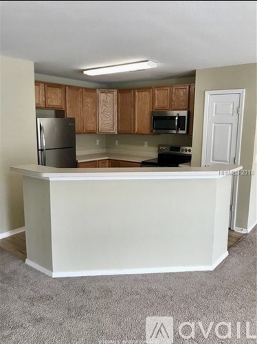 A kitchen with a white counter and wooden cabinets.
