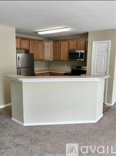A kitchen with a white counter and wooden cabinets.