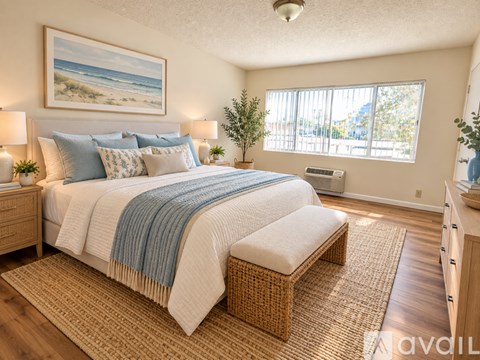 A bedroom with a large bed and a painting of a beach on the wall.