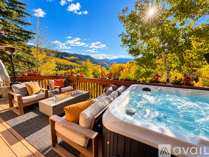A hot tub on a wooden deck with a mountain view in the background.