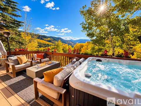 A hot tub on a wooden deck with a mountain view in the background.
