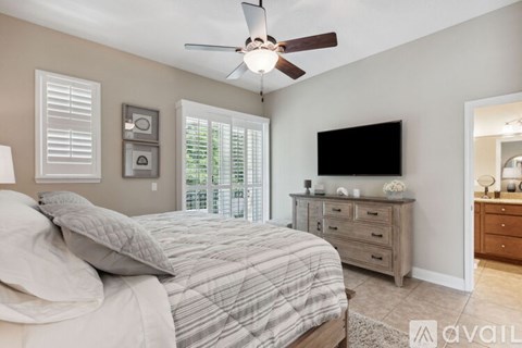 A bedroom with a large bed and a ceiling fan.