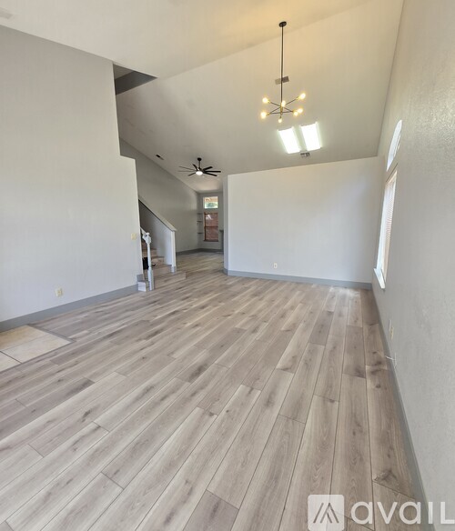 A room with wooden flooring and a ceiling fan.