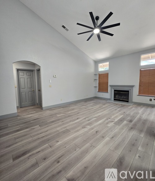 A room with wooden flooring and a fireplace.