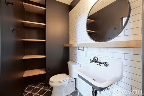 A bathroom with a toilet, sink and mirror.