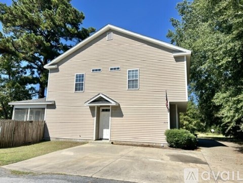 A house with a beige siding and a brown fence is for sale.
