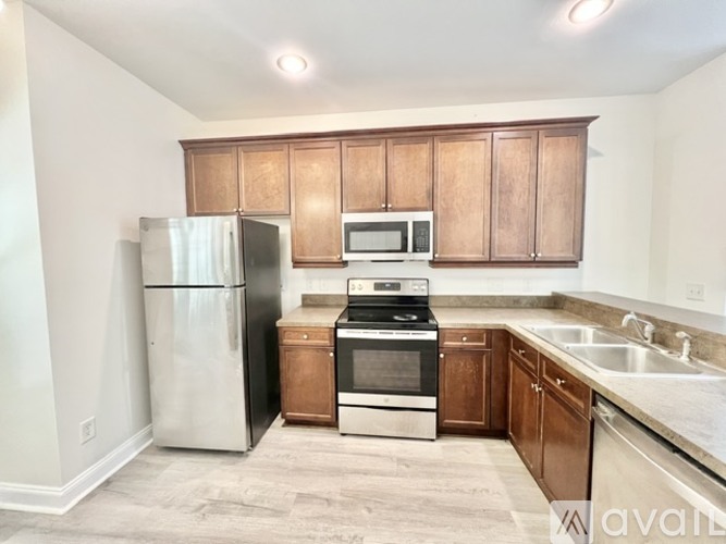 A kitchen with wooden cabinets and stainless steel appliances.