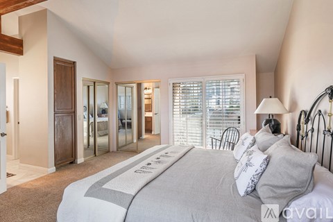 A bedroom with a large bed and a sliding glass door.