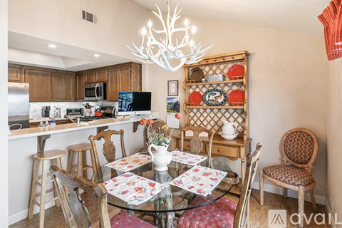 A dining room with a glass table and chairs.