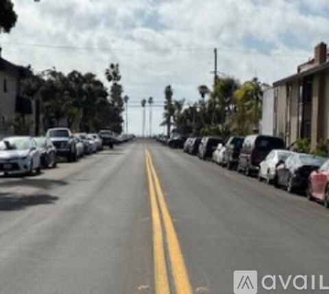 A street with cars parked on both sides.