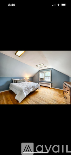 A bedroom with a bed, nightstand, and window.
