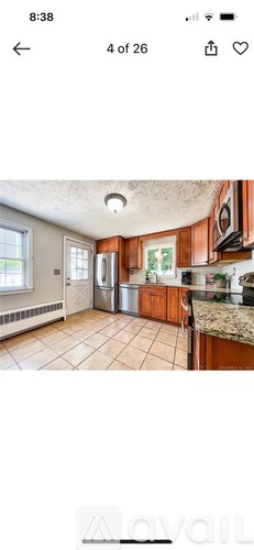 A kitchen with brown cabinets and a granite countertop.