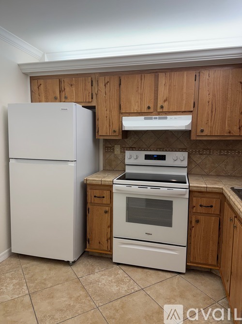 A kitchen with a white refrigerator and a white stove top oven.