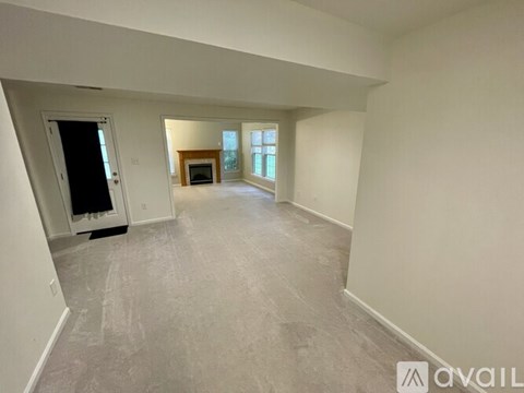 A spacious room with a door, a window, and a fireplace.