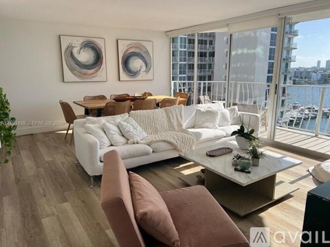 A living room with a white couch and brown pillows.