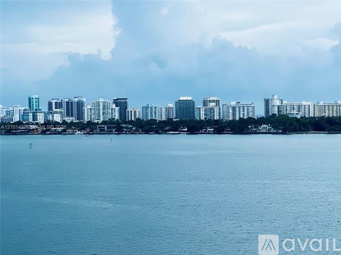 A city skyline with buildings and a body of water in the foreground.