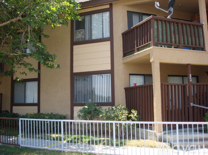 A white fence surrounds a building with brown railings.