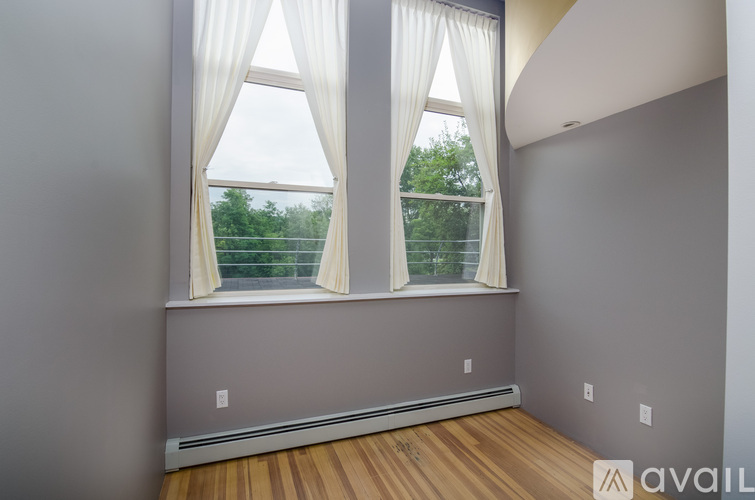 A room with a window and a view of trees outside.