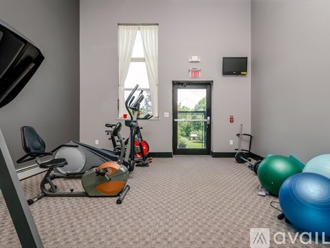 A gym room with exercise equipment and a window.