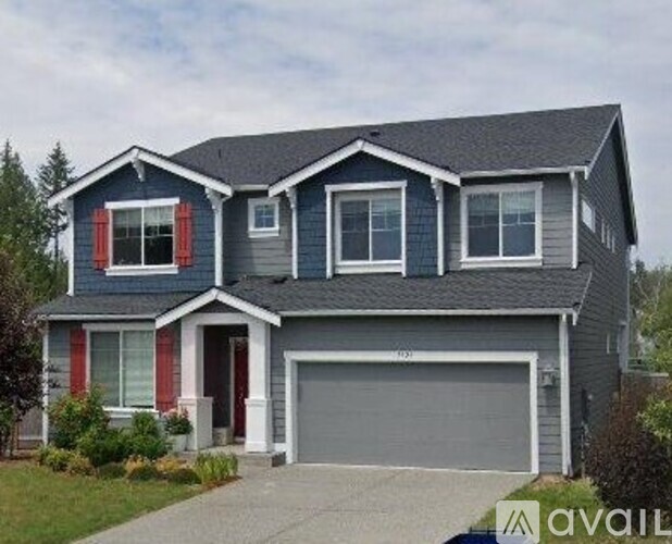 A two-story house with a grey garage door.