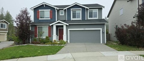 A two-story house with a garage is for sale.