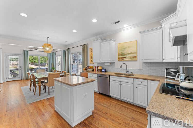 A kitchen with white cabinets and a wooden island.