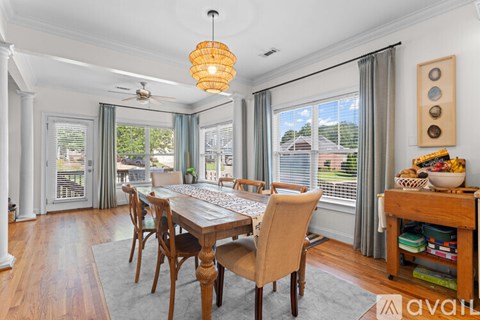 A dining room with a wooden table and chairs.