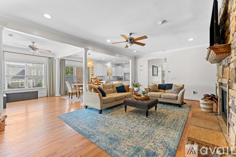 A living room with a blue rug and a fireplace.