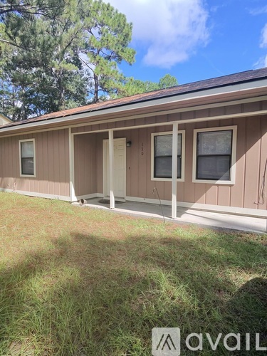 A house with a brown siding and a white door is for sale.