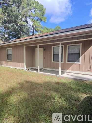 A house with a brown siding and a white door is for sale.