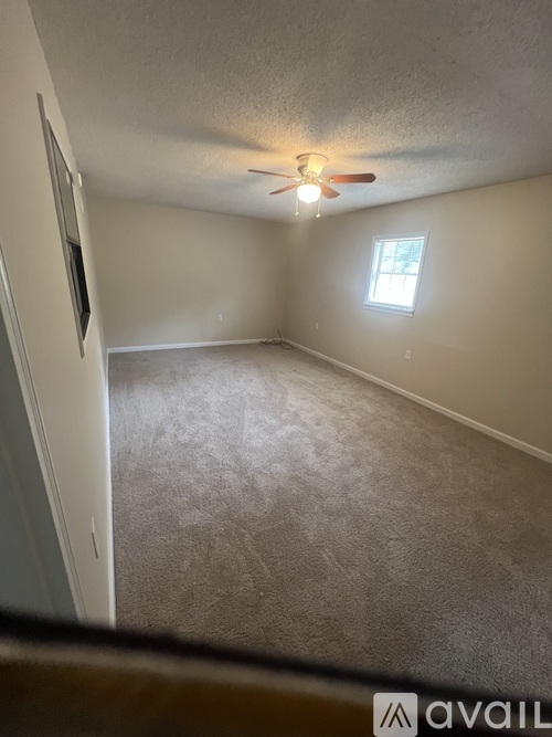 A room with a ceiling fan and a window.