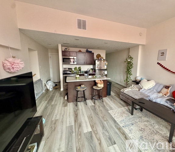 A living room with a kitchen area in the background.