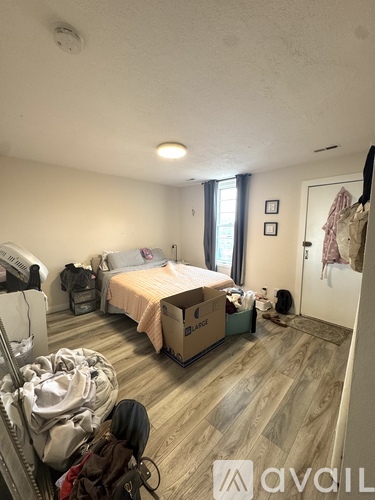 A room with a bed, a wardrobe and a dresser.