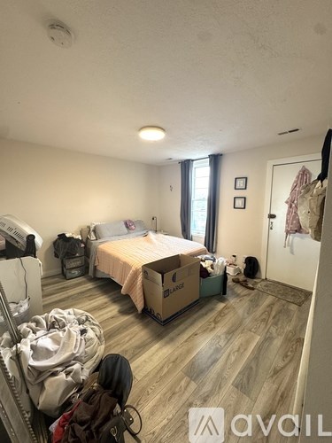A room with a bed, a wardrobe and a dresser.