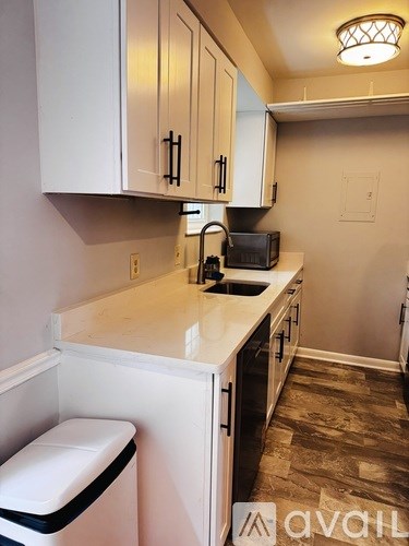 A kitchen with white cabinets and a black toaster on the counter.