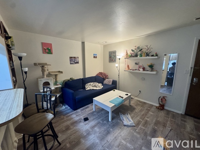 A living room with a blue couch and a white coffee table.